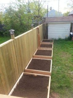 a wooden fence with steps leading up to it and dirt on the ground in front