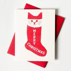 a red christmas card with a cat in a stocking