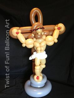 an inflatable balloon sculpture of a man holding a cross on a black background