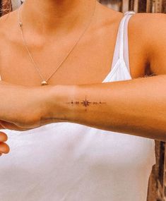 a woman with a cross tattoo on her arm