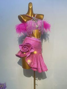 a mannequin dressed in pink with feathers and beads