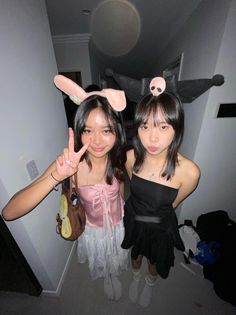 two young women standing next to each other with bunny ears on their head and one holding up the peace sign