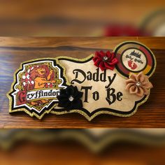 a wooden sign that says daddy to be with flowers on it and a bow in the middle