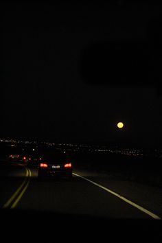 a car driving down the road at night