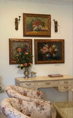 a living room with paintings on the wall and a white chair in front of it