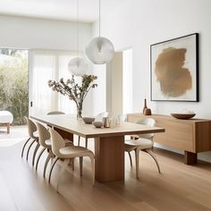 a dining room table with chairs and vases on it