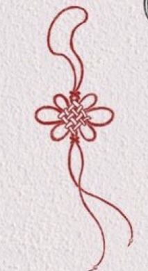 a red string is attached to the side of a piece of paper with an intricate design on it