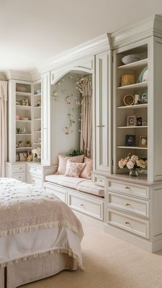 a white bed sitting in a bedroom next to a book shelf filled with lots of books