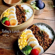 two bowls filled with food on top of a wooden table