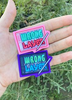 two stickers that say wrong layer and wrong layer on them in the palm of someone's hand