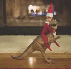 an image of a toy dinosaur with a elf on it's back