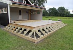 a house that has been built into the grass with steps leading up to it and an open porch