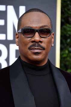 an image of a man wearing sunglasses and a black suit at the golden globe awards