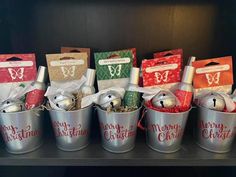 several buckets filled with different types of christmas decorations and gift bags on top of a shelf