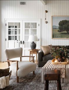 a living room filled with furniture and a painting on the wall