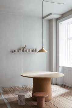 a white room with a round table and two stools