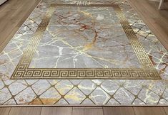 an area rug with gold trimmings and greek border on the floor in a living room