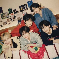 group of young men laying on top of a bed