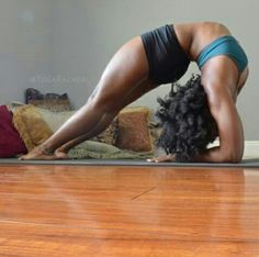 a woman is doing yoga on the floor with her head down and hands behind her back