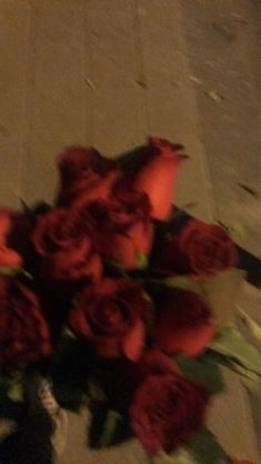 a bouquet of red roses sitting on the ground