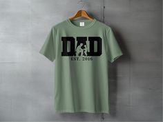 Celebrate fatherhood with this personalized Dad T-Shirt featuring "Dad Established 2016". A perfect custom Father's Day gift, this shirt makes a wonderful present for new dads and established fathers alike. Customize the year to mark the memorable moment of becoming a dad. This unique tee is not only stylish but also meaningful, making it the ideal gift to show appreciation for dad on Father's Day or any special occasion. Product Features: Fabrication: Medium fabric (6.1 oz/yd² (206.8 g/m. Garment-dyed fabric. 100% ring-spun cotton Fit: Relaxed fit Sizing: Unisex Sizing Label: Sewn-in twill label Soccer Dad Shirt, Soccer Design, Papa Shirts, Gifts For New Dads, Dad Birthday Gift, New Dads, Dad Birthday, Dyed Fabric, Dad To Be Shirts