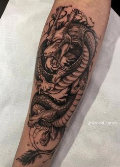 a black and white tattoo on the arm of a man with a dragon in it