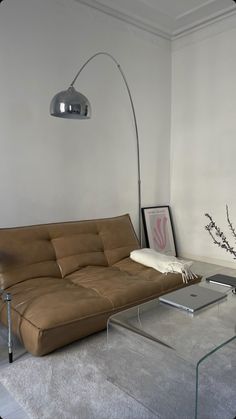 a living room with a couch, coffee table and lamp on the wall in front of it