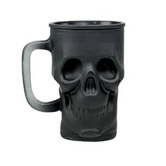 a black coffee mug with a skull face on it's front and side handles