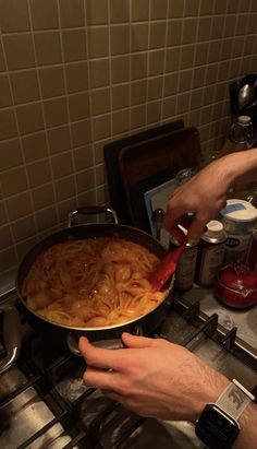 someone is cooking pasta in a pan on the stove