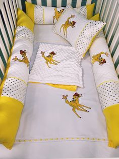 a baby crib bed with yellow and white sheets