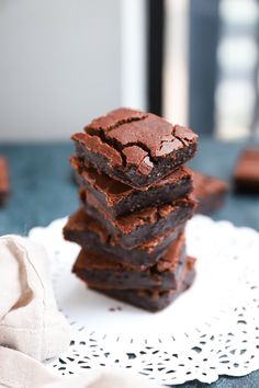 a stack of brownies sitting on top of a white doily