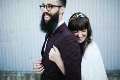 a man with a beard hugging a woman wearing a white dress and gold head piece