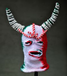 a knitted mask with red, white and green designs on it's face