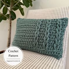 a crochet pillow sitting on top of a couch next to a potted plant