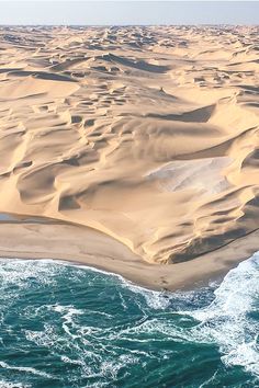 an aerial view of the ocean and sand dunes