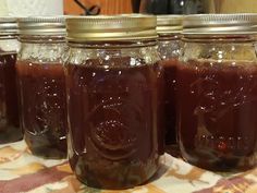 four jars filled with liquid sitting on top of a table