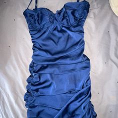 a blue dress laying on top of a bed