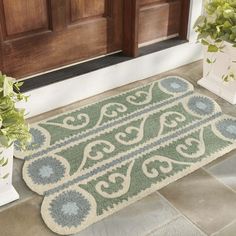 a blue and white door mat sitting on the ground next to a potted plant