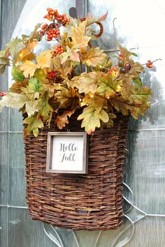 a basket filled with leaves and a sign that says hello fall