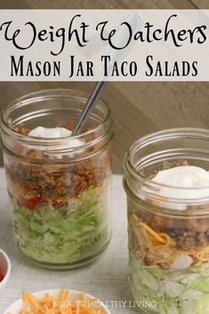 two mason jars filled with salads on top of a white tablecloth and text overlay that reads, the weight & watchers mason jar taco salads