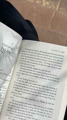 an open book sitting on top of a person's lap in front of a brick floor