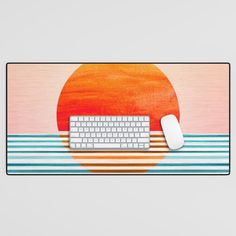 a computer keyboard and mouse sitting on top of a mouse pad with the sun in the background