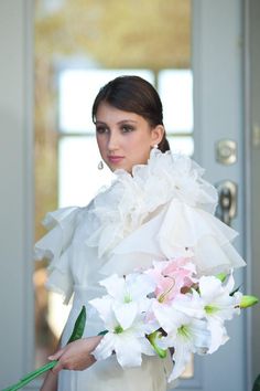 a woman holding a bouquet of flowers in her hands