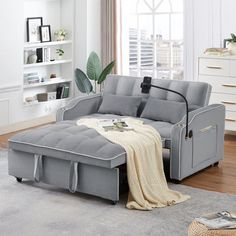 a living room scene with focus on the grey couch and white carpeted flooring