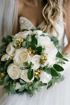 a bridal holding a bouquet of white flowers and greenery