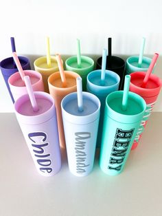 there are many different colored cups with straws in them on the table next to each other