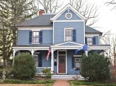 a blue house with an american flag on the front porch