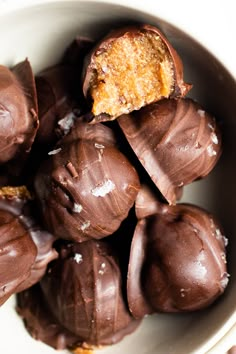 a white bowl filled with chocolate covered candies