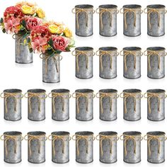 a bunch of metal canisters with flowers in them and tied up to each other