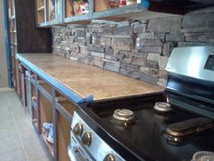 a stove top oven sitting inside of a kitchen next to a counter with an oven